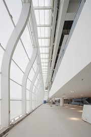 Die 170 x 20 m messende Ostfassade aus weiß bedrucktem Glas, sphärisch verformten Glas gilt als das größte Video-Display weltweit