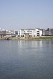 Blick über die Maas auf den nördlichen Teil des Centre Céramique: Die Brücke von Greisch, das weiße Appartementhaus von Coenen, dahinter der schwarze Riegel von Galfetti