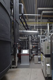 Der zentrale Technikraum der solaren Kühlung. Links der dunkle, hohe Behälter ist der Puffer-Speicher. In der Bildmitte der Bildschirm der zentralen Steuereinheit