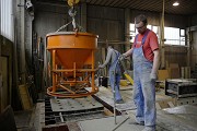 The workers place a perforated form panel over the reinforcement prior to casting. This simple trick effectively prevents formation of unsightly concrete circles